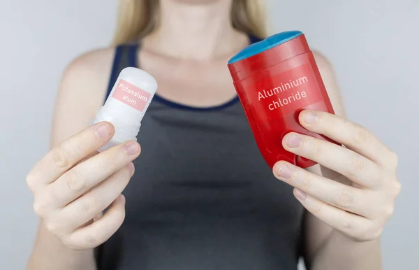 left or right. Girl chooses between eco-friendly deodorant without toxins and antiperspirant with toxic elements. In left hand Mineral alum crystal stick, in right hand classic remedy chemical nature