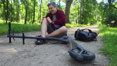 Adam elektrikli scooter sürerken düşmüş. Koruyucu giysi olmadan e-scooter kullanmak. Pille çalışan araçlar kullanıldığında yaralanma riski artıyor. Araba kullanırken güvenliği sağlamada sorun kavramı