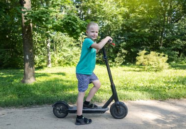 Çocuk elektrikli scooter sürerken düşmüş. Koruyucu giysi olmadan e-scooter kullanmak. Pille çalışan araçlar kullanıldığında yaralanma riski artıyor. Araba kullanırken güvenliği sağlamada sorun kavramı