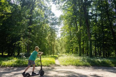 Çocuk elektrikli scooter sürerken düşmüş. Koruyucu giysi olmadan e-scooter kullanmak. Pille çalışan araçlar kullanıldığında yaralanma riski artıyor. Araba kullanırken güvenliği sağlamada sorun kavramı