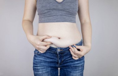 Obezite selüliti. Kadın belinde aşırı yağ kıvrımları. Önce ve sonra. Kilo verme, spor yapma, diyet ve yoğun eğitimin sonuçlarını kontrol etme kavramı. Kilo vermenin sonucu. Yağ aldırma