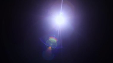 Siyah arka planda parıltı. Işığa doğrultulmuş bir kamera özel bir işaret fişeği etkisi yaratır. Bir güneş ışığı ve gökkuşağı renk tayfı. Parıltılar ve gradyanlar. Optik yanılsama