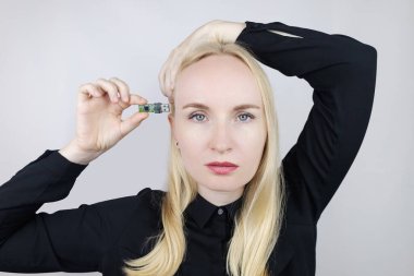 Usb 'un hafıza kartı kafasında. Beyne giden flaş bellek. Kız elinde hafıza kartıyla duruyor ve onu vücuduna sokmak istiyor. Sibernetizasyon ve hızlı öğrenme teknolojileri. Zihnini geliştiriyorsun.