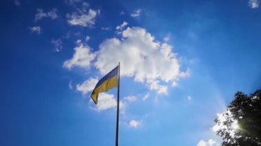 Ukrayna bayrağı, parlak bir gökyüzünün arkaplanına ve güneşin parıltısına karşı. Ukrayna Bayrağı. Beyaz ve gobun kumaş rüzgarda yavaşça esiyor. Parlak bir gelecek için umut ve inanç hissi yaratıyor.. 