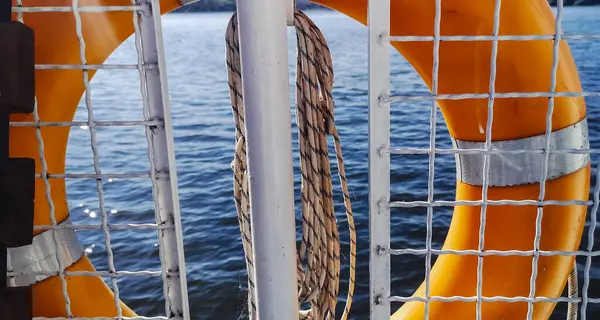 救生圈 从游艇上看到的水 阳光照射在海浪上 营造出一种安全和欢乐的气氛 Fence Rope Rescue Equipment — 图库照片