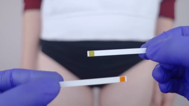 细菌性阴道病 阴道Ph值 女孩展示了测量生殖器官酸碱平衡的棒 自我诊断 以颜色显示的正常酸度水平 必须与标准进行比较 — 图库视频影像