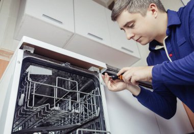 Bulaşık makinesi tamiri. Bir hizmet merkezi temsilcisi evde bulaşık makinesini teşhis eder ve tamir eder. Ev aletleri konusunda uzmanım. Evine bir teknisyen çağır. Yakın plan.