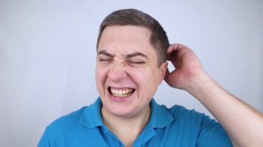 Adam kafa ovuyor. Koyu renk saçlı genç adam kepek, yağlı kafa derisi ve saç dökülmesi için kafa derisini yüzüyor. Cilt problemi saç problemlerine neden oluyor. Kendi kendine masaj ve saç teline sürtünme..