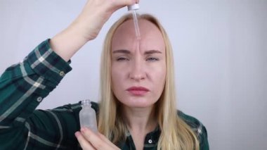 Retinol. Bir kız yüzüne antioksidan kırışıklık önleyici krem sürüyor. Yaşlanma önleyici ve yüz tazeleme ajanı. A vitamini derin kırışıklıkları azaltır ve yumuşatır. Önce ve sonra. Görsel sonuç