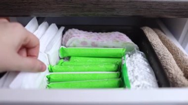 Hijyenik peçete, tampon ve pamuk çiçeği. Kadınlar regl olmak için içinde hijyen ürünleri olan çekmeceyi açarlar. Pamuk çiçeği plastiğin yokluğunu sembolize eder. Çevresel malzemelerden yapıldı