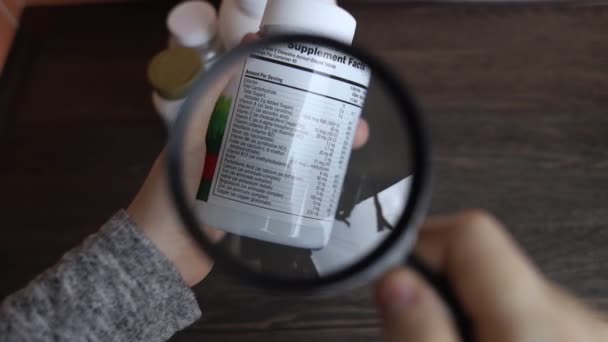 Chica Estudia Suplementos Dietéticos Leyendo Las Instrucciones Frasco Complejo Vitamínico — Vídeo de stock