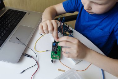Programming for children. The boy is studying online at a robotics school for programming courses. Child learning control board coding