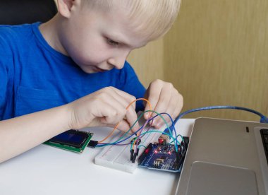 Programming for children. The boy is studying online at a robotics school for programming courses. Child learning control board coding