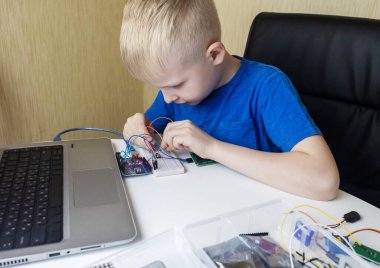 Programming for children. The boy is studying online at a robotics school for programming courses. Child learning control board coding