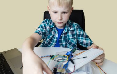 Programming for children. The boy is studying online at a robotics school for programming courses. Child learning control board coding