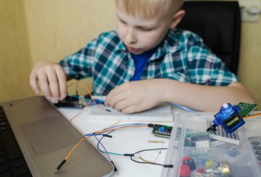 Programming for children. The boy is studying online at a robotics school for programming courses. Child learning control board coding