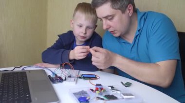 Programming for children. A teacher teaches a child at a robotics and IT school. Boy learning to code control board