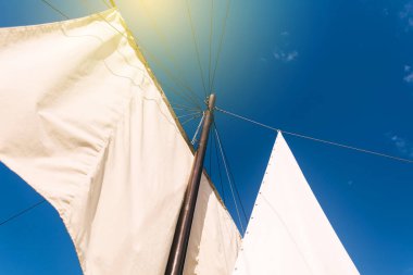 Beyaz yelkenli, bulutlu mavi gökyüzünün arka planında. Yat ve yelkencilik. Yaz tatili ve deniz seyahati