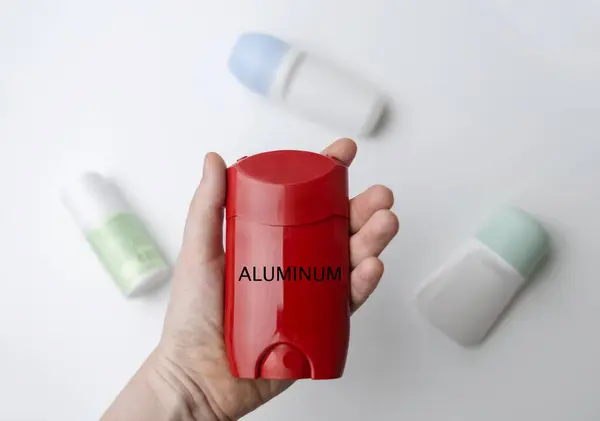 stock image Aluminum in deodorant. Dangerous components and ingredients in care cosmetics. Protection of armpits from sweating. Ball and solid antiperspirants on the table, viewed under a magnifying glass