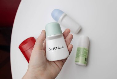 Deodorantlı gliserin. Bakım için güvenli bileşenler ve kozmetik malzemeleri. Koltuk altlarının terlemekten korunması. Masada terletici maddeler var, büyüteç altında görünüyor.