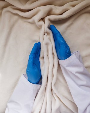 The hands of a gynecologist support the folds of soft tissue in the shape of the labia, vagina and vulva. The concept of women's intimate health, prevention of gynecological diseases