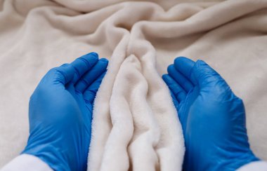 The hands of a gynecologist support the folds of soft tissue in the shape of the labia, vagina and vulva. The concept of women's intimate health, prevention of gynecological diseases