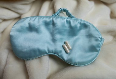 Bir kadın uyuyamaz ve bir kapsül melatoninle uyku hapı içmek ister. Jitlag veya uykusuzluk belirtileri. Biyolojik ritimlerin düzenlenmesi