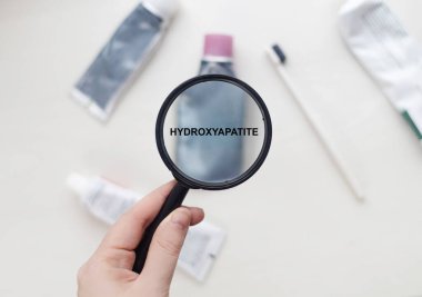 Doğal diş macununda hidroksatit. Büyüteç, içinde güvenli bir ürünün bileşenleri olan bir tüpe yönlendirilir. Güvenli diş macunu bileşimi
