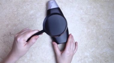 Bir kutu şampuanı elinde tutan kadın elleri, ne bir yazı ne de bir sembol var. Paketin yüzeyinde metin için boşluk aç. Hijyen ürününün altındaki siyah beyaz plastik kutu.