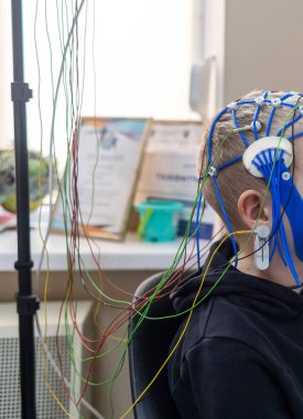 Bir çocuğun beyni EEG makinesinde incelenir. Elektroensefalogram nörolojik hastalıkların tespiti için bir hastane laboratuvarında yapılır. Çocuklar için ensefalogram