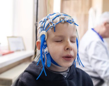 Bir çocuğun beyni EEG makinesinde incelenir. Elektroensefalogram nörolojik hastalıkların tespiti için bir hastane laboratuvarında yapılır. Çocuklar için ensefalogram