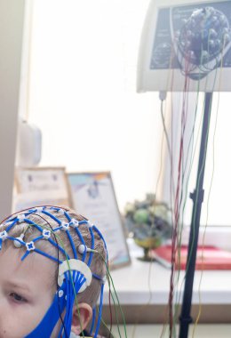Bir çocuğun beyni EEG makinesinde incelenir. Elektroensefalogram nörolojik hastalıkların tespiti için bir hastane laboratuvarında yapılır. Çocuklar için ensefalogram