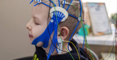 Bir çocuğun beyni EEG makinesinde incelenir. Elektroensefalogram nörolojik hastalıkların tespiti için bir hastane laboratuvarında yapılır. Çocuklar için ensefalogram
