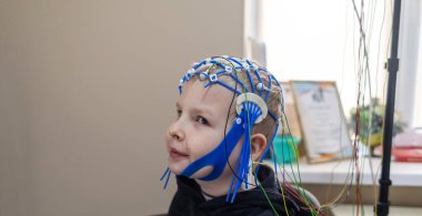 Bir çocuğun beyni EEG makinesinde incelenir. Elektroensefalogram nörolojik hastalıkların tespiti için bir hastane laboratuvarında yapılır. Çocuklar için ensefalogram