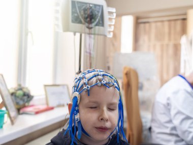 Bir çocuğun beyni EEG makinesinde incelenir. Elektroensefalogram nörolojik hastalıkların tespiti için bir hastane laboratuvarında yapılır. Çocuklar için ensefalogram