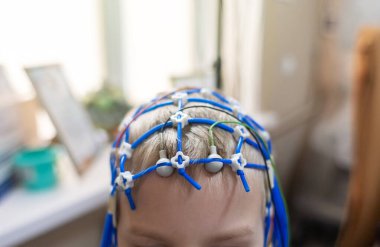Bir çocuğun beyni EEG makinesinde incelenir. Elektroensefalogram nörolojik hastalıkların tespiti için bir hastane laboratuvarında yapılır. Çocuklar için ensefalogram