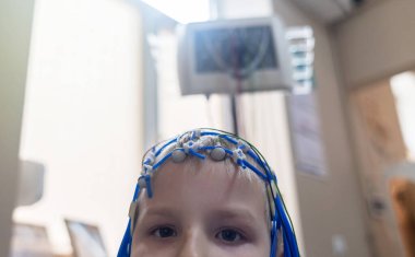 Bir çocuğun beyni EEG makinesinde incelenir. Elektroensefalogram nörolojik hastalıkların tespiti için bir hastane laboratuvarında yapılır. Çocuklar için ensefalogram