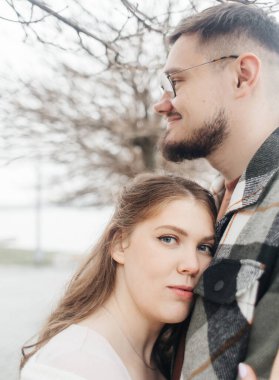 Yürüyüşe çıkmış şık elbiseli genç bir çift. Romantik bir buluşma. Yürü, öpücükler ve sarılmalar