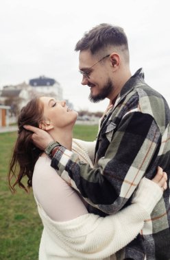 Yürüyüşe çıkmış şık elbiseli genç bir çift. Romantik bir buluşma. Yürü, öpücükler ve sarılmalar