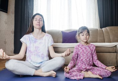 Anne ve kızı evde yoga ve meditasyon yapıyorlar. Evde birlikte antrenman yaparız. Eğlenceli ve aktif aile zamanı