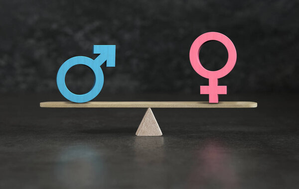Gender equality and sexual equality conceptual image with male and female icon symbols in balance on a seesaw.