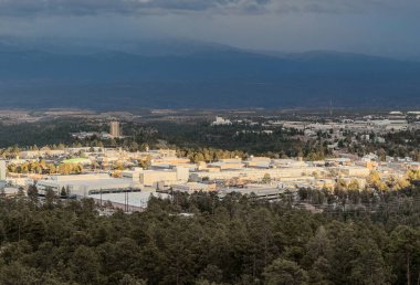 Ray of sunlight breaking through cloud coverage lighting Los Alamos National Laboratory, Los Alamos, New Mexico clipart