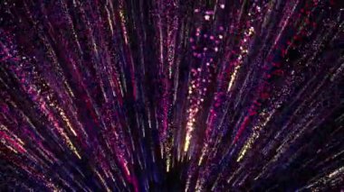 Parlak renkli parçacıklar boşluğu enerji ve ışık püskürtüleriyle doldurur. Parlak şenlik dekorasyonu için parlak renkli soyut arkaplan