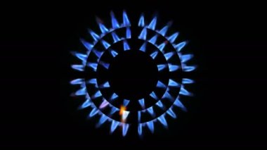 Geceleri parlayan bir mutfak ocağının üst görüntüsü, yakın plan. Doğal gaz konsepti. Gaz sobası yanan bir ocakla açılıyor.