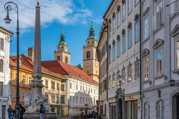 LJUBJANA, SLOVENIA - NOVEMBER 05.2022: Slovakya 'nın başkentindeki mimari binalarla sokak manzarası, Katedral Kulesi' nin arka planı