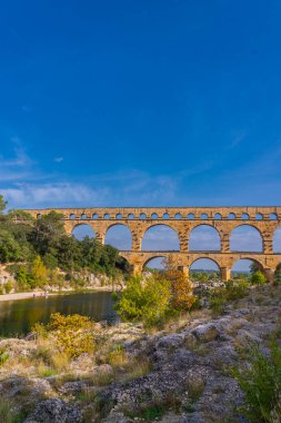 Gardon nehrindeki turuncu kireçtaşlı Pont du Gard su kemerine dikey bir bakış. Kaynak