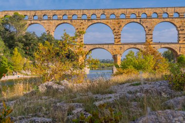 Gardon nehrinin üç katlı turuncu kireçtaşı Pont du Gard su kemeri manzaralı. Kaynak