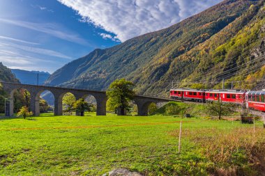 BRÜZİO, SWitzERLAND - 28 Ekim 2022: Rhaetian Demiryolu Hattı 'ndan Bernina Express İtalya' da bir sonbahar gününde