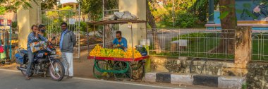 Puttaparthi, Andra Pradesh, India - January 18.2023:Indian man selling fresh orange juice at the street in Puttaparthi