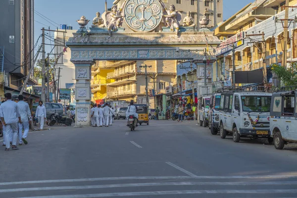 Puttaparthi, Andra Pradesh, India - January 18.2023: Jung Indian man in white closes walking along the road to the Sai Baba Ashram